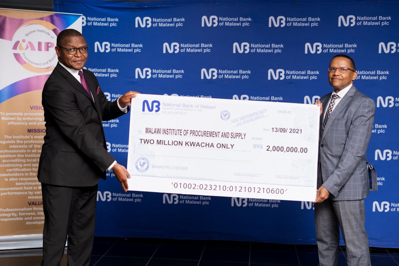 NBM Head of Operations Brian Boby right presenting a symbolic cheque to MIPS CEO Feston Kaupa