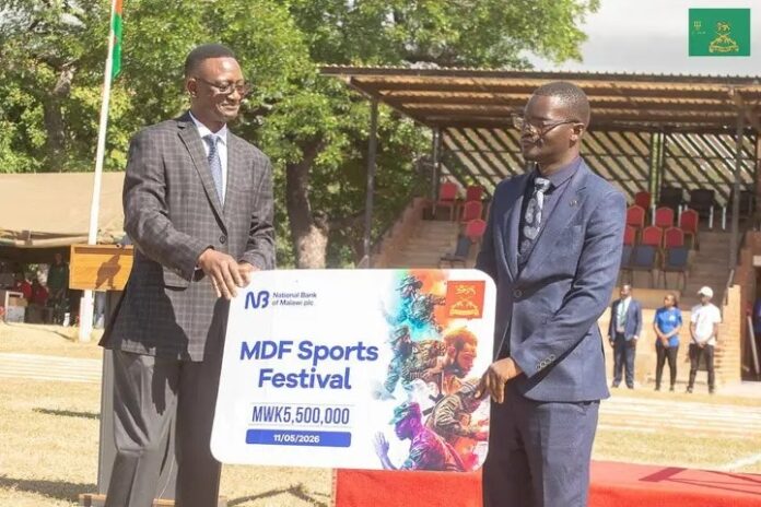 Banda (right) handing over the dummy cheque to Jaffu