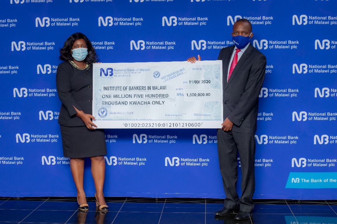 Kaunda (right) presents the dummy cheque to Nkungula