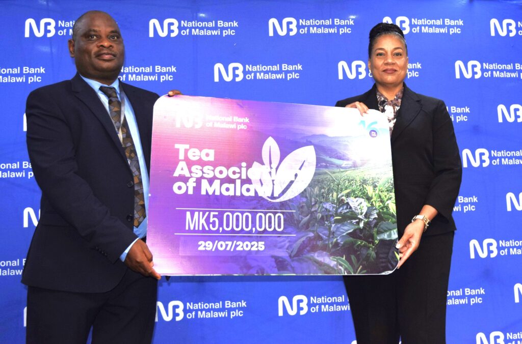 Chirwa (Right) handing over a dummy cheque to Suluma